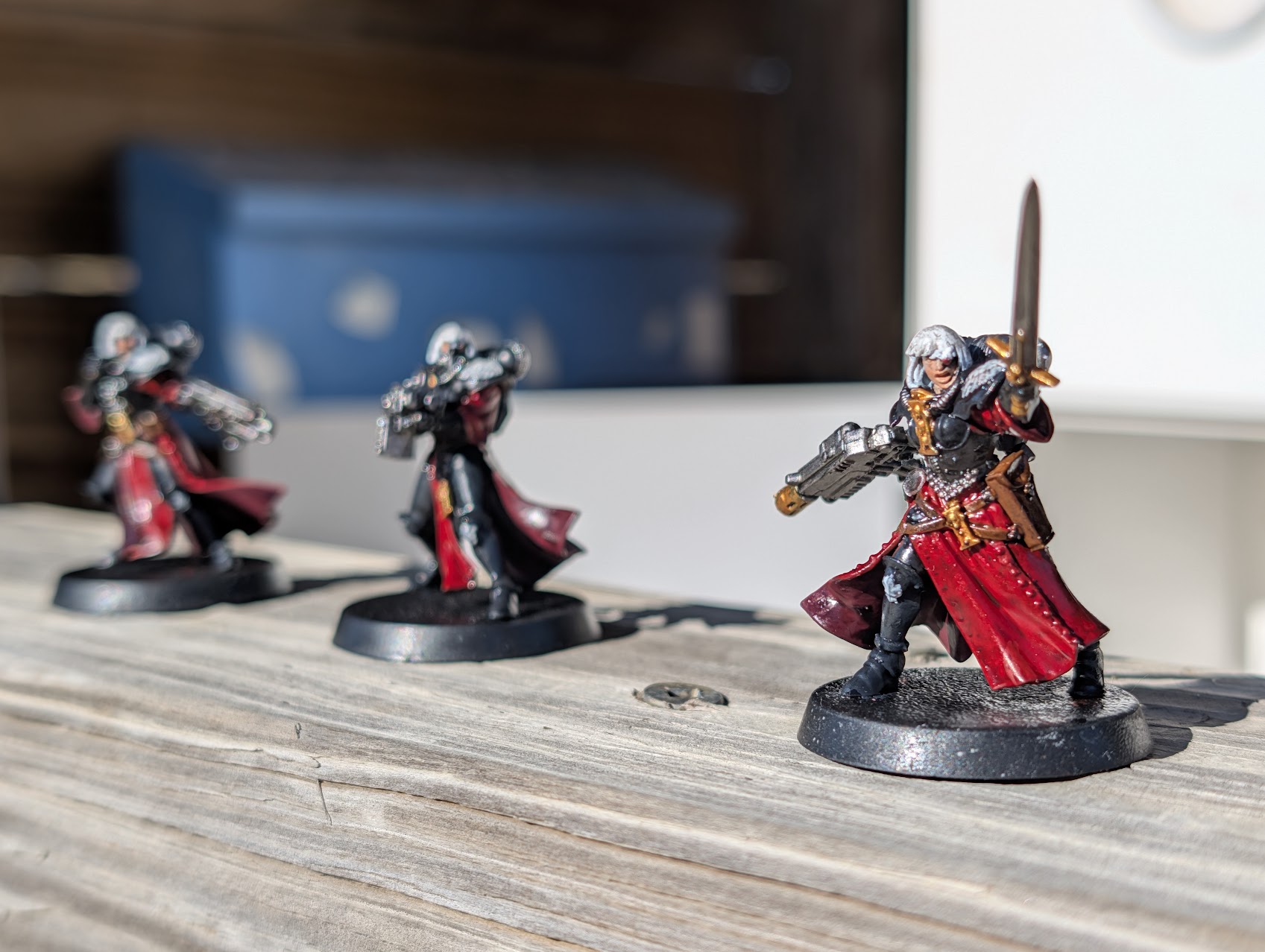 A few Warhammer 40k Sisters of Battle miniatures arranged outdoors for a photo.